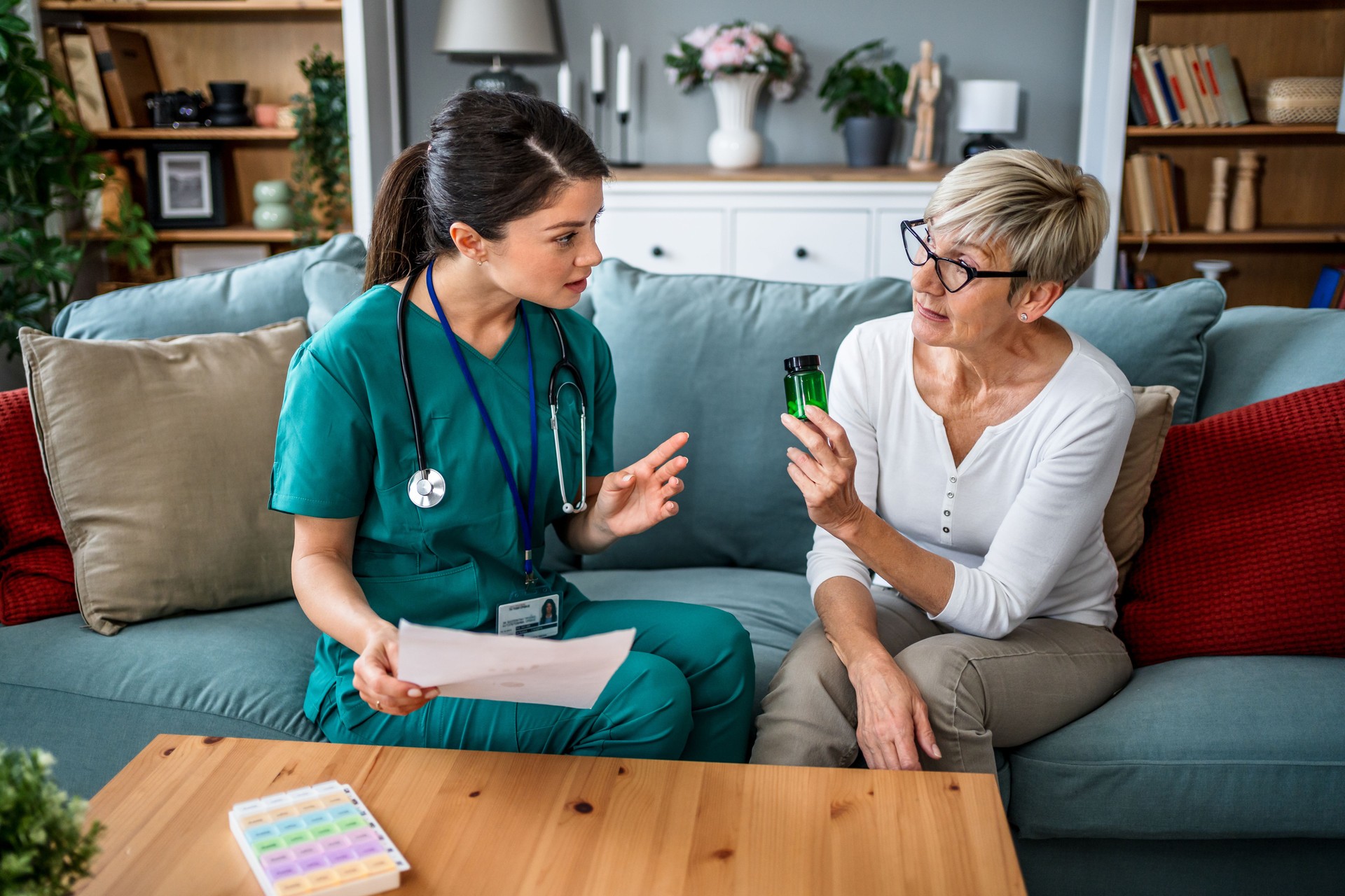 Nurse explaining medicine prescription to senior woman at home