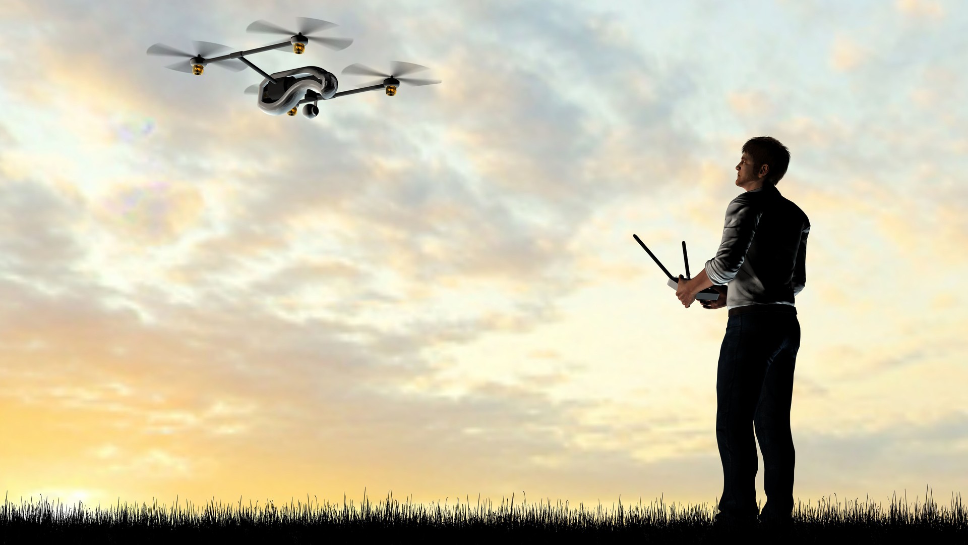 Man operating a drone quadrocopter at sunset using a controller